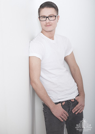 Portrait of a young man in a white t-shirt and jeans looking at the camera