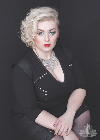 Portrait of a curvy young woman with red lipstick looking at the camera