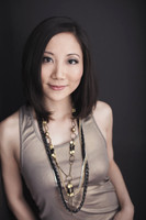 Studio portrait of a young Asian woman smiling at the camera