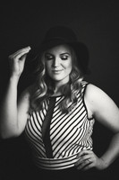 Black and white portrait of a young woman with a floppy hat and striped top