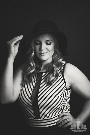 Black and white portrait of a young woman with a floppy hat and striped top