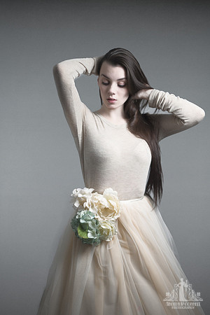 Studio portrait of a young woman in a tutu with flowers running her hands through her long hair