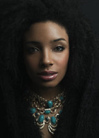 Portrait of a young black woman wearing gold and turquoise necklaces