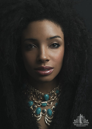 Portrait of a young black woman wearing gold and turquoise necklaces