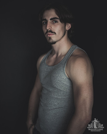 Portrait of a young man with a mustache looking at the camera