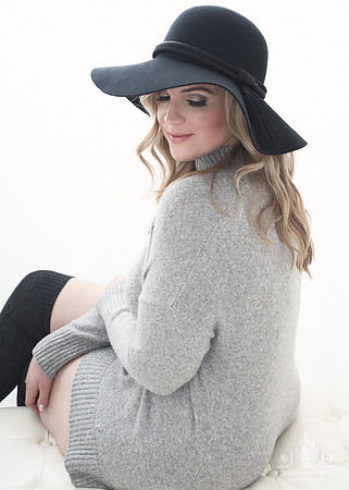 Portrait of a woman sitting with a floppy black hat