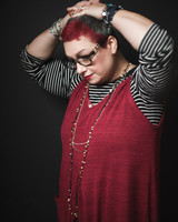 Portrait of woman with red hair in a red dress and jewellery