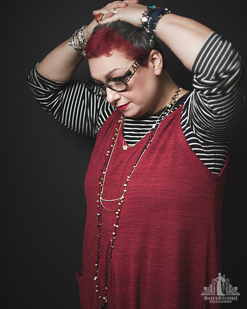 Portrait of woman with red hair in a red dress and jewellery