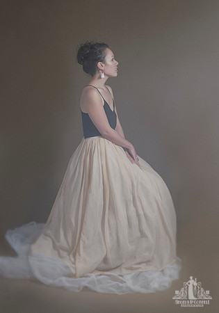 Contemporary studio portrait of a young Maori woman posing in a tulle dress with her hands clasped in front of her by Vancouver portrait photographer Angela McConnell