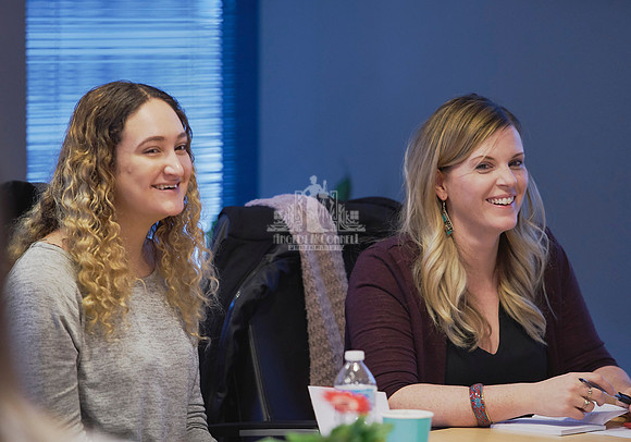 Two women smile as the participate in an exercise during a workshop