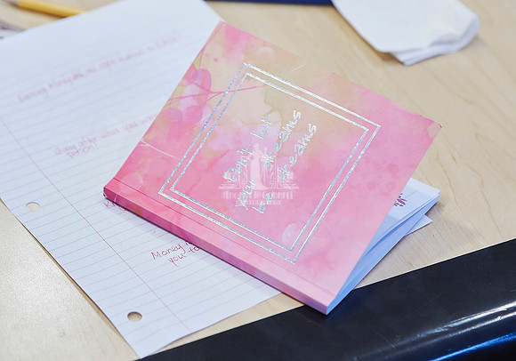 A workbook and paper sitting on a board room table during a workshop