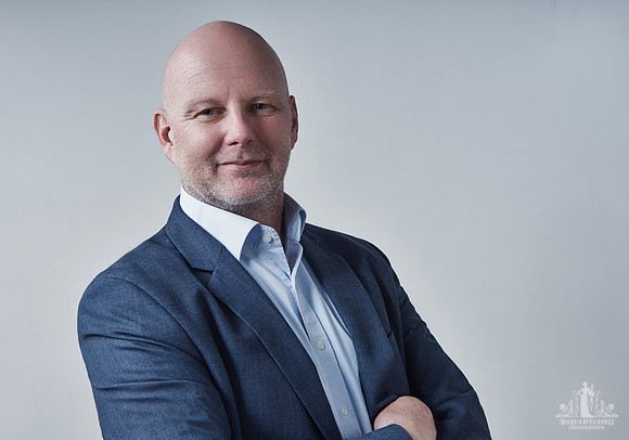 Man smiles at the camera during a life coach branding session with Vancouver business portrait and branding photographer Angela McConnell