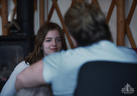 A daughter smiles at her mother as they sit on yoga mats during an exercise at a mother and daughter workshop by Vancouver workshop and retreat photographer Angela McConnell