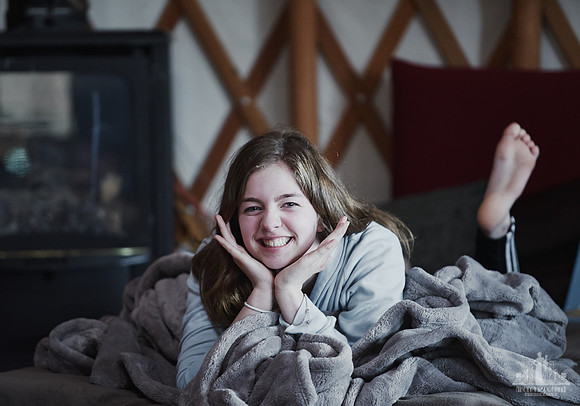 A young girl smiles at the camera during an excercise  at a mother and daughter workshop by Vancouver workshop and retreat photographer Angela McConnell