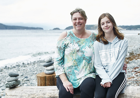 A mother and daughter hug during portraits on a beach  at a mother and daughter workshop by Vancouver workshop and retreat photographer Angela McConnell