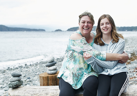 A mother and daughter hug during portraits on a beach  at a mother and daughter workshop by Vancouver workshop and retreat photographer Angela McConnell