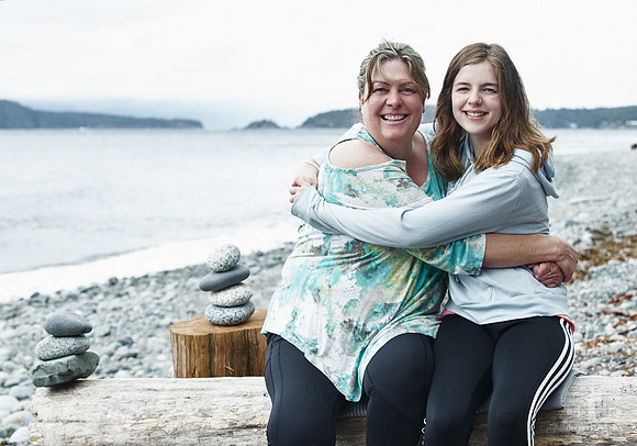 A mother and daughter hug during portraits on a beach  at a mother and daughter workshop by Vancouver workshop and retreat photographer Angela McConnell