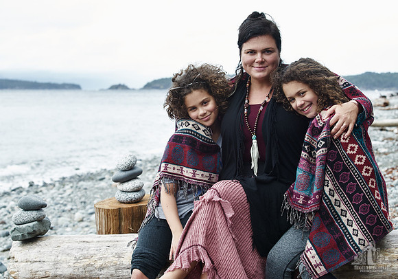 A mother and her daughters hug during portraits on a beach  at a mother and daughter workshop by Vancouver workshop and retreat photographer Angela McConnell