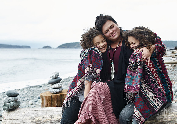 A mother and her daughters hug during portraits on a beach  at a mother and daughter workshop by Vancouver workshop and retreat photographer Angela McConnell