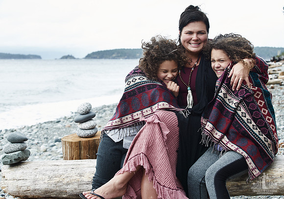 A mother and her daughters hug during portraits on a beach  at a mother and daughter workshop by Vancouver workshop and retreat photographer Angela McConnell