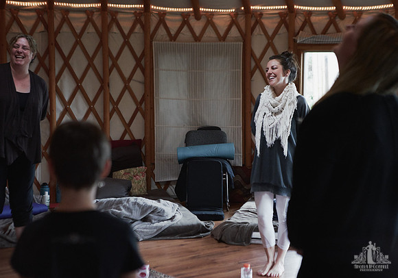 A facilitator smiles at attendees during an exercise  at a mother and daughter workshop by Vancouver workshop and retreat photographer Angela McConnell