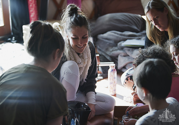 A facilitator smiles at attendees during an exercise  at a mother and daughter workshop by Vancouver workshop and retreat photographer Angela McConnell