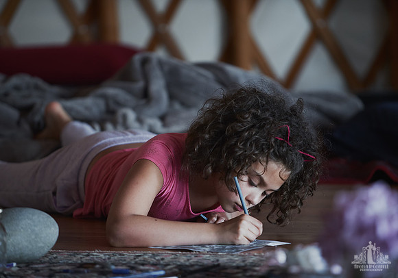 A young girl writes a letter during an exercise at a mother and daughter workshop by Vancouver workshop and retreat photographer Angela McConnell