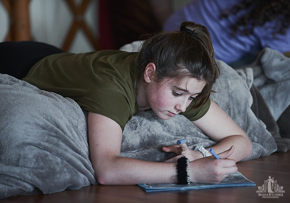 A young girl writes a letter during an exercise at a mother and daughter workshop by Vancouver workshop and retreat photographer Angela McConnell