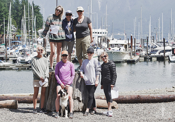 Women and an Australian shepherd pose during a group photo at Bowen Island at a courage and bravery workshop by Vancouver workshop and retreat photographer Angela McConnell