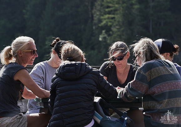 Women smile as they listen to each other discuss an exercise at a courage and bravery workshop by Vancouver workshop and retreat photographer Angela McConnell
