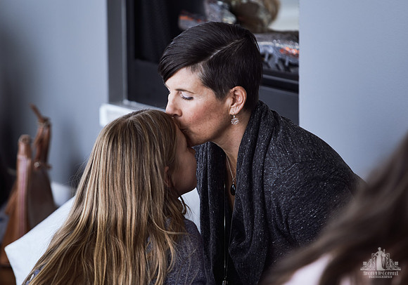A mother kisses her daughter on the forehead during an exercise at a mother and daughter workshop by Vancouver workshop and retreat photographer Angela McConnell