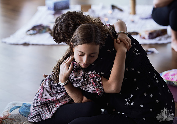 A mother and daughter hug during an exercise at a mother and daughter workshop by Vancouver workshop and retreat photographer Angela McConnell