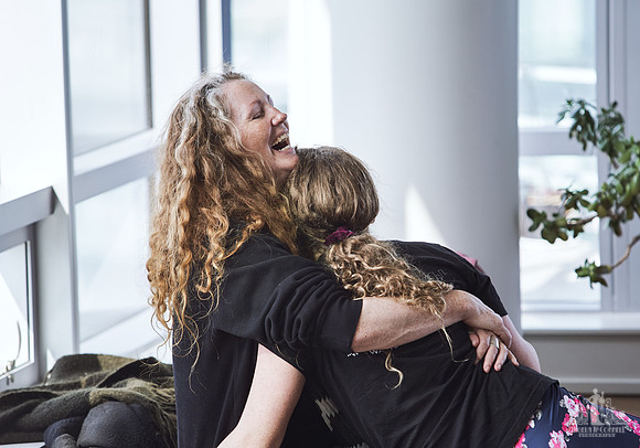 A mother laughs as she hugs her daughter during an exercise at a mother and daughter workshop by Vancouver workshop and retreat photographer Angela McConnell