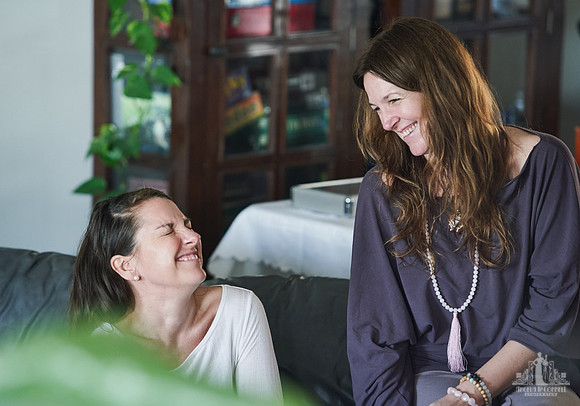 Two women laugh together during a group exercise  at a womens' retreat at Halfmoon Haven on the Sunshine Coast, BC by Vancouver workshop and retreat photographer Angela McConnell