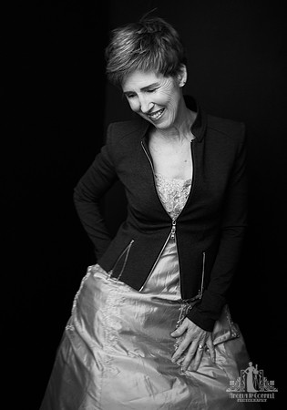 Black and white portrait of an older woman in a formal dress laughing