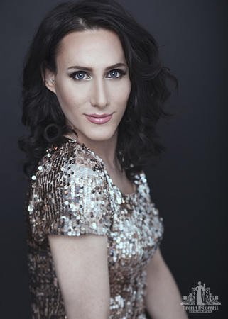 Contemporary studio portrait of a young woman in a sequin dress smiling at the camera by Vancouver portrait photographer Angela McConnell