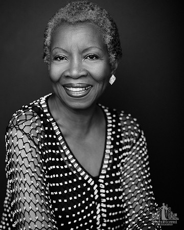Black and white portrait of an older black woman smiling at the camera